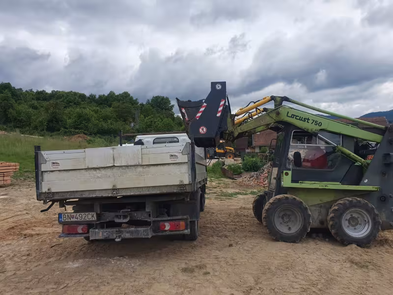 Nakladanie šmykom riadeného nakladača Locust 750 na korbu JakoKAM.